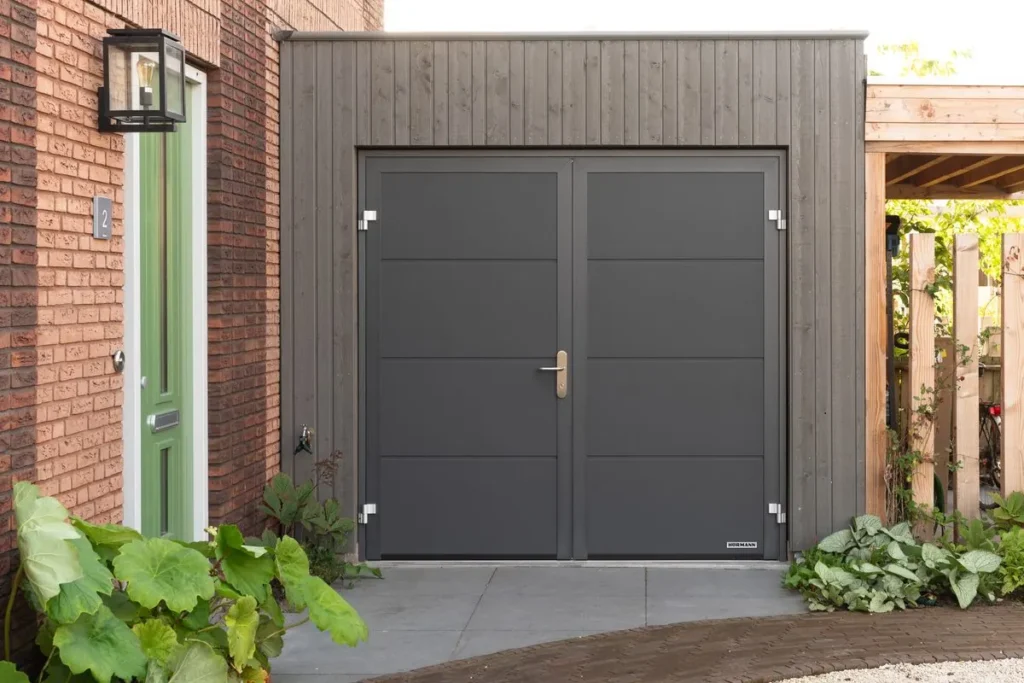 Antraciete openslaande Hormann garagedeuren in een houten gevel