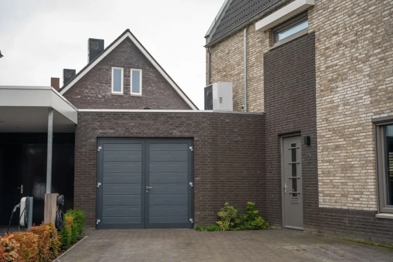 Antraciete openslaande Hormann garagedeur bij een moderne woning